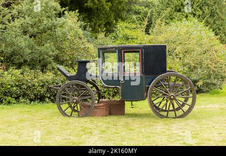 Alte grüne vierrädrige Pferdekutsche auf dem Gelände des Anwesens Stockfoto