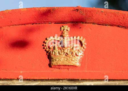 High Halden, Kent, vereinigtes Königreich, 21, August, 2022 Nahaufnahme der Oberseite einer traditionellen englischen roten Telefonbox, mit goldlackierter Krone Stockfoto