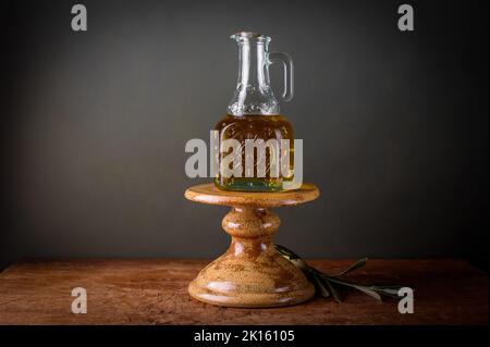 Olivenöl im Retro-Glas auf dem Kuchenständer. Stockfoto