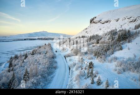 Straße in der Nähe von verschneiten Bergen am Morgen Stockfoto