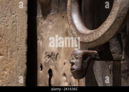 Nahaufnahme des Eingangsportals des Klosters Sant Cugat in Spanien. Mittelalterliche Holztür, Detail von Riegel und Griff. Seitenansicht. Stockfoto