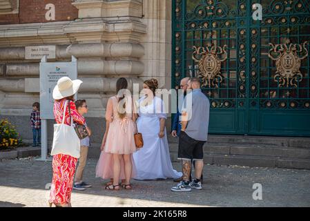 Europa, Frankreich, Dunkerque - 9. Juli 2022: Kleine Gruppe von Menschen versammeln sich um Braut in Weiß warten auf Bräutigam Ankunft vor dem Haupteingang zu Stockfoto