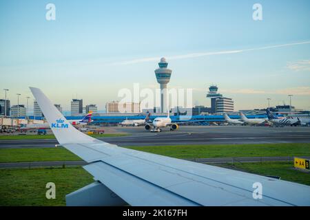 Blick auf den Amsterdam Airport Schiphol Tower vom Flugzeug aus, das auf der Start- und Landebahn rollt Stockfoto