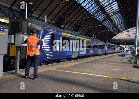 Ein Zugdisponent bereitet einen Zug für die Abfahrt von der Queen Street Station, Glasgow, Schottland, Großbritannien, vor Stockfoto