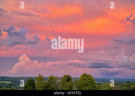 Wunderschöne Gewitterwolken bei Sonnenuntergang über dem Sommerfeld. Stockfoto