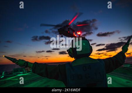 Ostsee. 3. September 2022. U.S. Navy Boatswain Mate 3. Klasse Neil Kennedy aus Key West, Florida, führt einen MH-60s Sea Hawk Hubschrauber, der dem Hubschrauber Sea Combat Squadron (HSC) 28 zugewiesen wurde, um auf dem Flugdeck des Arleigh Burke-Klasse Lenkraketen-Zerstörers USS Paul Ignatius (DDG 117) zu landen, 3. September 2022. Paul Ignatius ist Teil der Kearsarge Amphibious Ready Group und hat 22. Marine Expeditionary Unit unter dem Kommando und der Kontrolle der Task Force 61/2 mit einem geplanten Einsatz im Einsatzgebiet der US Naval Forces Europe, beschäftigt von der US Sixth Fleet zur Verteidigung der USA, Stockfoto