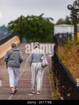 Zwei ältere Frauen, die im Herbstpark spazieren. Konzept des aktiven Alterns. Reisefoto, selektiver Fokus, verschwommen Stockfoto