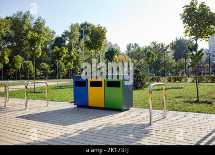 Mülltonnen im Stadtpark. Müllcontainer in einem öffentlichen Park. Umwelt, Stadtleben, sanitäre Standards Stockfoto