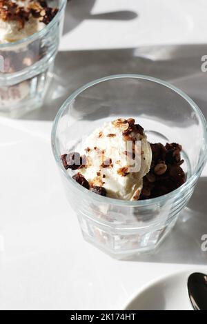 Hausgemachtes Müsli-Dessert mit Vanilleeis in Gläsern. Stockfoto