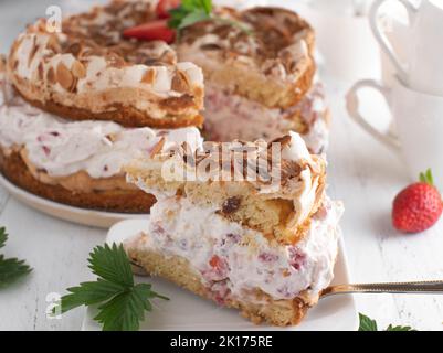 Erdbeer-Sahnetorte mit Baiser, Mandel-Belag. Traditionelles deutsches Dessert Stockfoto