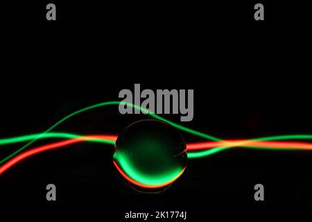 Abstraktes Bild mit Lichtmalerei, einer Kristallkugel und grünem und rotem Licht Stockfoto