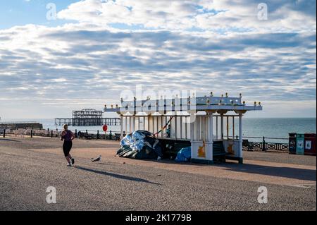 Brighton UK 16. September 2022 - Ein Läufer kommt an einem Tierheim vorbei, in dem an der Küste von Brighton ein Obdachlosenlager errichtet wurde, an einem sonnigen, aber kühlen Tag, da die Temperaturen in den nächsten Tagen in Großbritannien voraussichtlich sinken werden: Credit Simon Dack / Alamy Live News Stockfoto