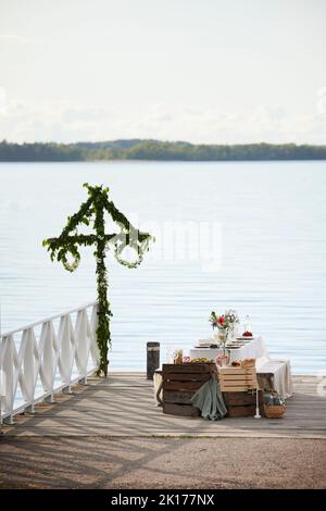 Tisch mit Mittsommeressen am See Stockfoto
