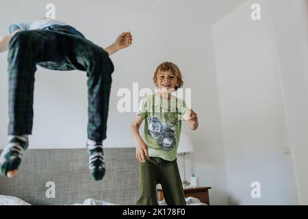Brüder springen zu Hause auf das Bett Stockfoto