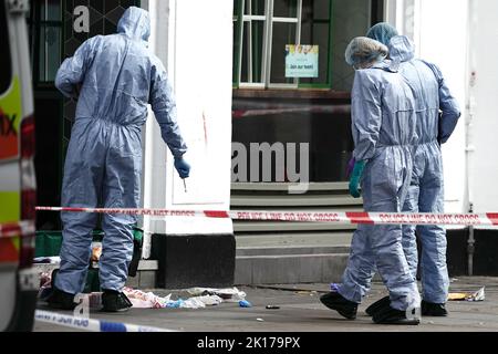 Forensische Beamte am Tatort in der Shaftesbury Avenue im Zentrum von London, wo zwei männliche Polizisten um 6am von einem Mann erstochen wurden. Beide Offiziere werden derzeit von Sanitätern behandelt. Der Verdächtige wurde wegen des Verdachts verhaftet, schwere körperliche Schäden verursacht und einen Nothelfer angegriffen zu haben. Bilddatum: Freitag, 16. September 2022. Stockfoto