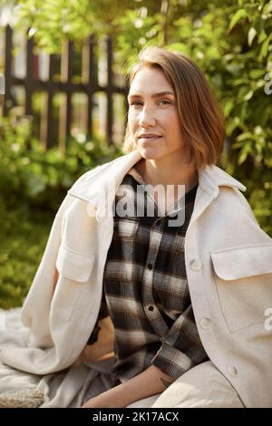 Portrait von Frau im Garten sitzen Stockfoto