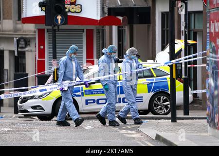 Forensische Beamte am Tatort in der Shaftesbury Avenue im Zentrum von London, wo zwei männliche Polizisten um 6am von einem Mann erstochen wurden. Beide Offiziere werden derzeit von Sanitätern behandelt. Der Verdächtige wurde wegen des Verdachts verhaftet, schwere körperliche Schäden verursacht und einen Nothelfer angegriffen zu haben. Bilddatum: Freitag, 16. September 2022. Stockfoto