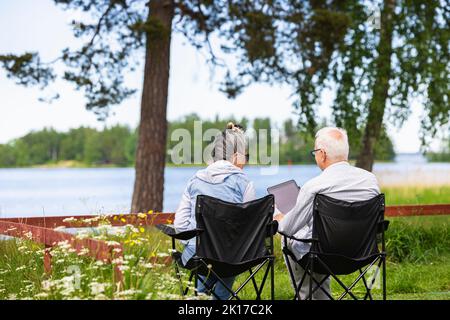 Seniorenpaar sitzt in Campingstühlen Stockfoto