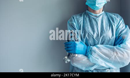 Porträt des Mediziners ohne Gesicht, gekleidet in einem medizinischen Einwegkleid und einer Schutzmaske Stockfoto