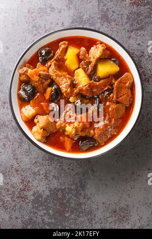 Lamm, Pflaume und Kartoffelragout in der Schüssel auf dem Tisch. Vertikale Draufsicht von oben Stockfoto