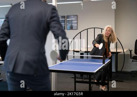 Geschäftsleute, die im Büro Tennis spielen Stockfoto