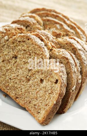 In Scheiben geschnittenes irisches Steinbrot oder Sodabrot auf einem weißen Teller. Weizenbrot wird aus Steinmehl und Buttermilch hergestellt und ist hefefrei Stockfoto