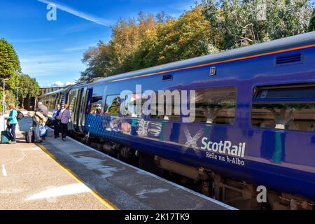 PLOCKTON STATION WESTER ROSS SCOTLAND IM SPÄTSOMMER PASSAGIERE AUF DEM BAHNSTEIG VERLASSEN EINEN SCOTRAIL ZUG Stockfoto