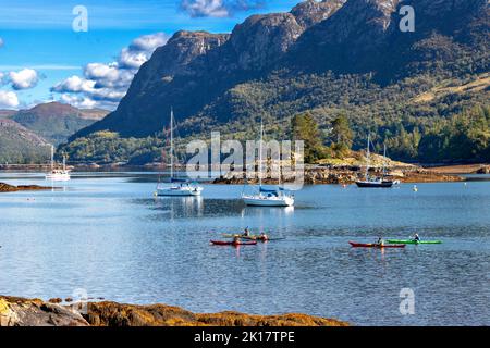 PLOCKTON WESTER ROSS SCHOTTLAND SPÄTSOMMER FARBENFROHE KANUS UND BOOTE AUF LOCH CARRON Stockfoto