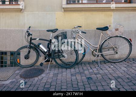 Fahrräder auf der Straße gegen die Wand geparkt Stockfoto