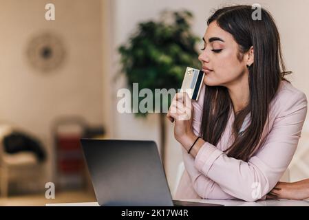 Nachdenkliche junge Erwachsene Frau in einem Anzug, denken, was als nächstes vom Online-Markt zu kaufen. Stockfoto