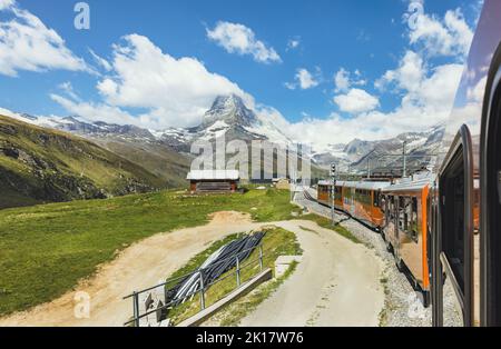 Roter Zug auf dem Hintergrund des Matterhorns in den Schweizer Alpen Stockfoto