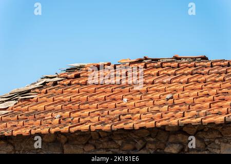 Nahaufnahme eines alten Hausdachs mit Terrakotta-Fliesen (Ton), auf einem klaren blauen Himmel mit Kopierraum. Ligurien, Italien, Europa. Stockfoto