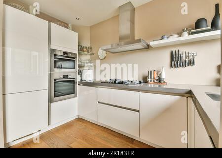 Home Interior Design der modernen Loft-Wohnung mit offener Küche In minimalistischem Stil und geräumiger Essecke mit Tisch und Stühle Stockfoto