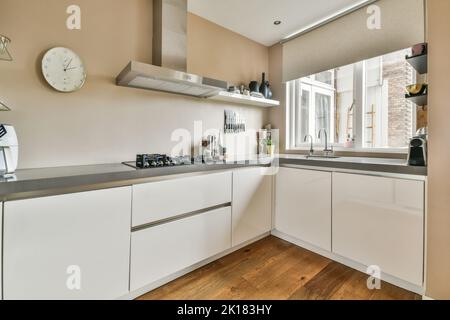 Home Interior Design der modernen Loft-Wohnung mit offener Küche In minimalistischem Stil und geräumiger Essecke mit Tisch und Stühle Stockfoto