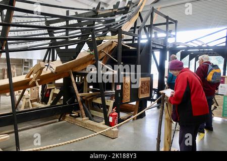 Woodbridge, Suffolk, Großbritannien - 16. September 2022 ; das Bootsbauprojekt Longshed am Whisstocks Square. Besucher unterschreiben das Gästebuch. Stockfoto