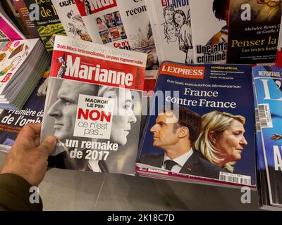 Paris, Frankreich - 17. Apr 2022: POV-Mann hält im Pressekioské die neueste Ausgabe von Marriane mit Macron Le Pen nein, dies ist kein Remake des Schlagzeilen-Titels von 2017 Stockfoto