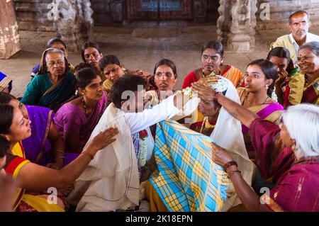 Hampi, Karnataka, Indien: Braut und Bräutigam führen ein Ritual während einer hinduistischen Hochzeit im Sree Virupaksha Tempel durch. Ununterbrochen . funktionierende Sünde Stockfoto