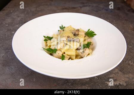 Fettuccine Huhn mit Pilzen in Sahnesauce. Stockfoto