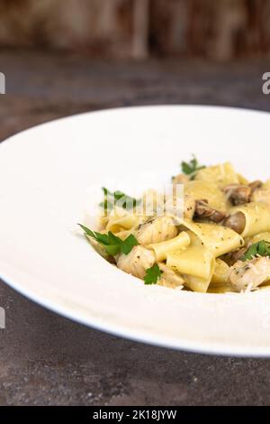 Fettuccine Huhn mit Pilzen in Sahnesauce. Stockfoto