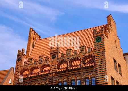 Dachteil und Giebel eines historischen Backsteingebäudes, Erzdiakwerk in der inneren Altstadt der Hansestadt Wismar, Deutschland. Stockfoto