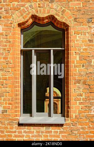 Vorhangbogenfenster in der Backsteinseitenwand des Fürstenhofs, der fürstlichen Residenz Wismars aus der Renaissance. Stockfoto