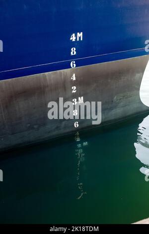 Wassertiefe Markierungen auf dem blau lackierten Rumpf eines Containerschiffes im Hafen Eivissa auf Ibiza, Balearen, Spanien. Stockfoto