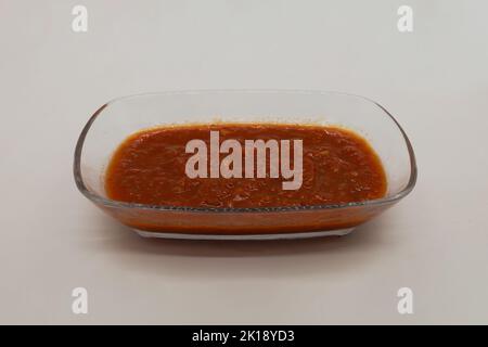 Tomatensoße zum Frühstück isoliert auf weißem Hintergrund. Rote Tomatensoße in Glasschale. Stockfoto