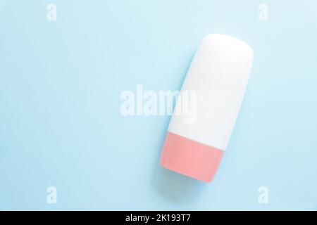 Mockup weiße Kosmetikröhrchen-Flasche mit rosa Schraubverschluss auf blauem Hintergrund. Feuchtigkeitsspendende Creme, Gel, Hautpflege, Sonnencreme, Feuchtigkeitscreme, lotion, Flüssig t Stockfoto