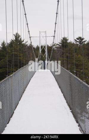 Eine verschneite Hängebrücke aus Metall Stockfoto