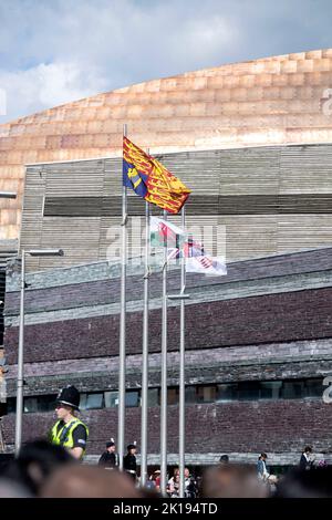 Cardiff, Großbritannien. 16. September 2022. Die Union Jack und die walisische Flagge fliegen am halben Mast neben der Royal Standard Flagge als Zeichen des Respekts für Ihre Majestät die Königin während des Besuches von König Charles III und Camilla, Queen Consort im Senedd Gebäude in Cardiff, Großbritannien, heute Nachmittag. Der Besuch des britischen Königspaares in Wales ist der letzte Halt auf ihrer Tour durch die vier Hauptstädte, anlässlich der Thronbesteigung des Königs nach dem Tod seiner Mutter, Königin Elizabeth. Quelle: Phil Rees/Alamy Live News Stockfoto