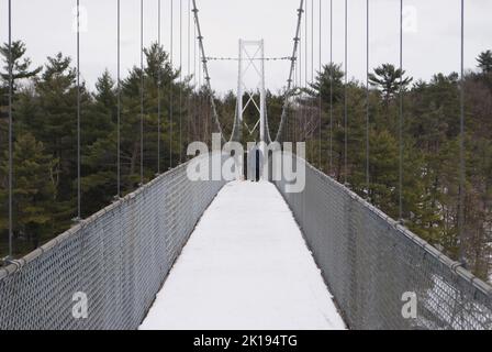 Eine verschneite Hängebrücke aus Metall Stockfoto