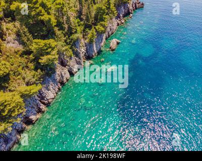 Malerisches Meer Adriaküste von Montenegro. Türkisfarbenes Mittelmeer und felsige Küste mit immergrünen Nadelbäumen. Wunderschöne Sommerlandschaft Stockfoto