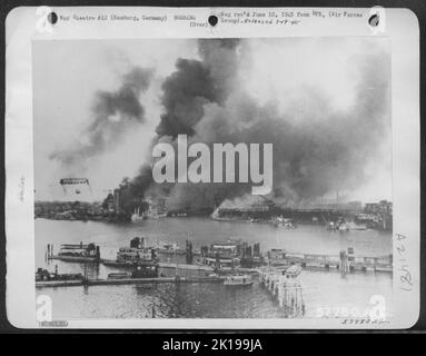 Die Deutschen machten Fotos von Hamburg nach einem der alliierten Angriffe, nach dem Europas größter Hafen im Nichtgebrauch lag. Rauch Wabert Schwarz Von Den Vorräten Am Hafen, Als Docks Und Schiffe Ins Wasser Gehen. Stockfoto