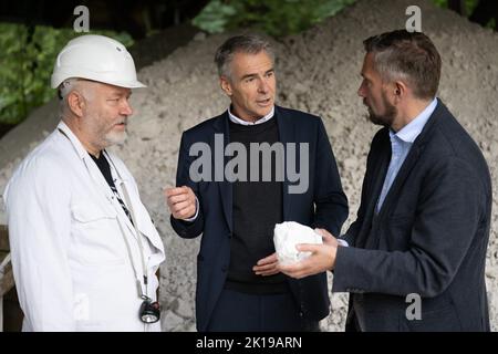 15. September 2022, Sachsen, Seilitz: Der sächsische Wirtschaftsminister Martin Durig (SPD, r) steht neben Andreas Kawka (l.), Steiger, und Tillmann Blaschke, Geschäftsführer der Porzellanmanufaktur, mit einem Stück Kaolin im Rahmen einer „Rohstofftour“ im Weißerdwerk Seilitz. Im Weißerdwerk wird seit 1764 ununterbrochen Kaolin für die Porzellanmanufaktur Meißen abgebaut. Foto: Sebastian Kahnert/dpa Stockfoto